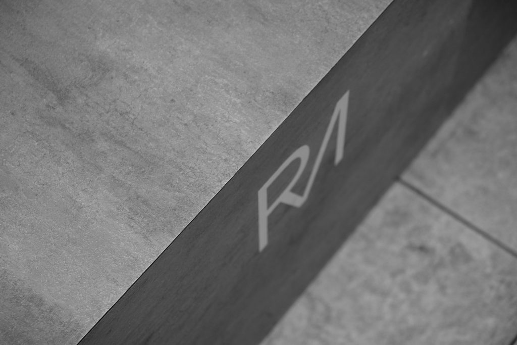 Close-up of concrete with a minimal logo in a monochrome tone, showcasing urban style.